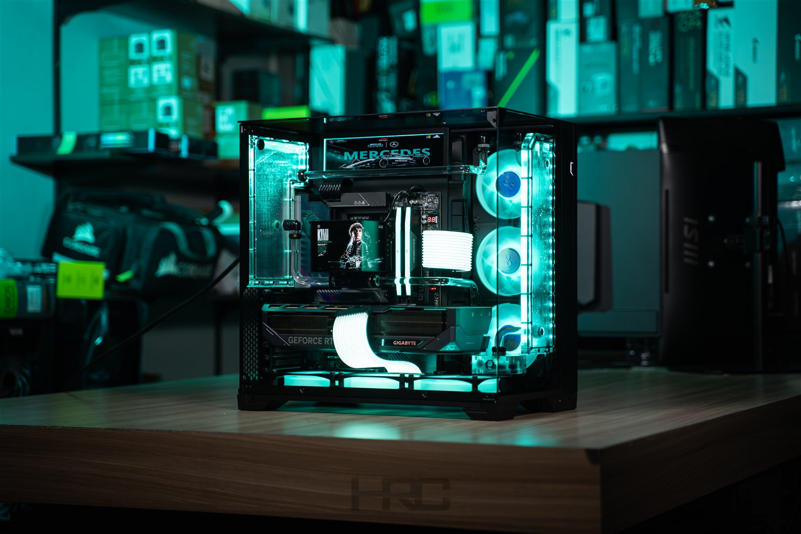 LIAN LI O11 VISION COMPACT. A black glass enclosure frames turquoise lighting, white cables and a custom cooling loop.