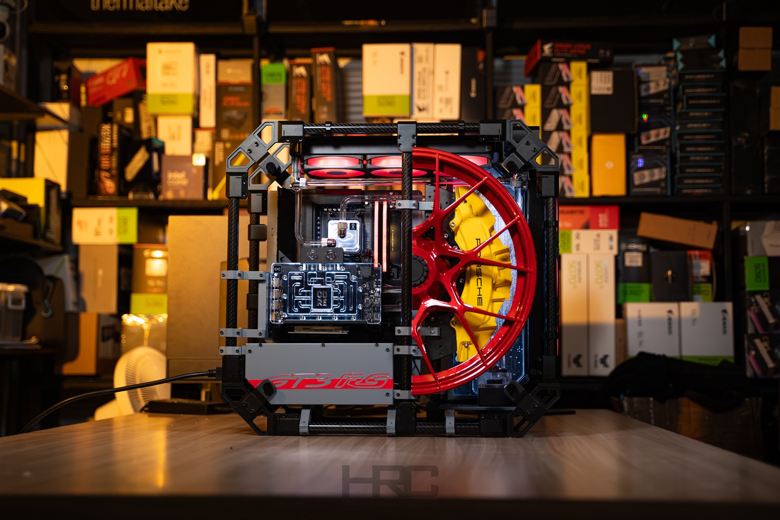ALPHACOOL APEX SKELETON. An open-frame build with a red wheel, yellow brake caliper and a custom liquid-cooling loop.